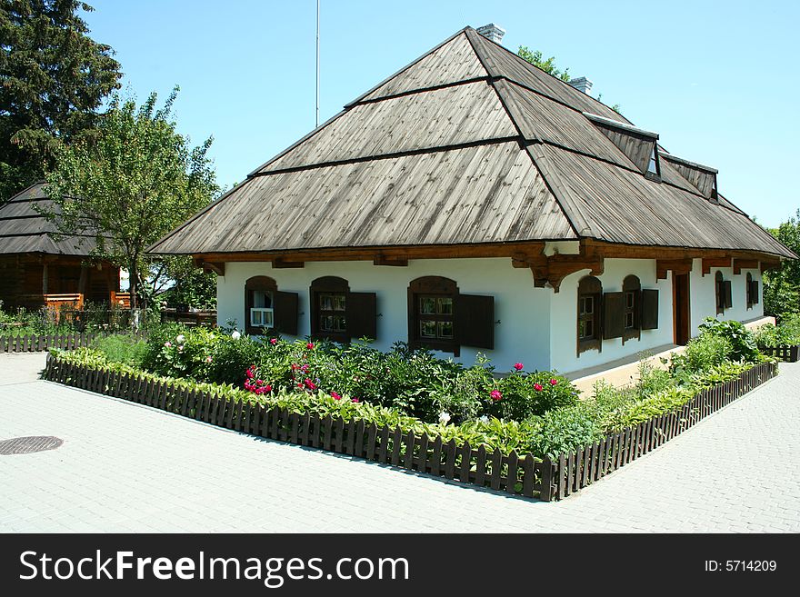 Hata-traditional Ukrainian housing and flowers in front of the windows. Hata-traditional Ukrainian housing and flowers in front of the windows