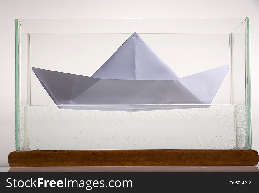 Paper boat in glass aquarium