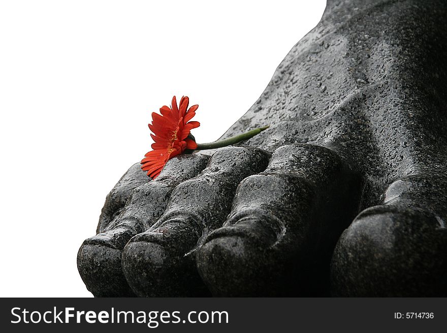 A part of a statue with a flower. A part of a statue with a flower