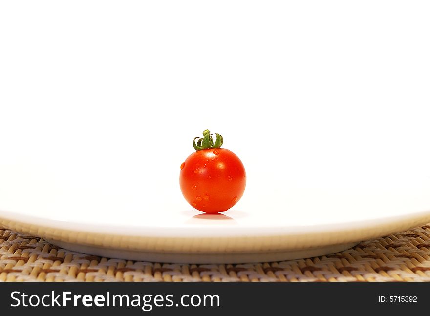 Ripe tomato on a plate isolated on a white background