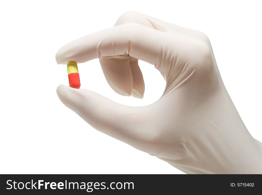 Red-and-yellow pill in nurse's hand,isolated, on white background. Red-and-yellow pill in nurse's hand,isolated, on white background