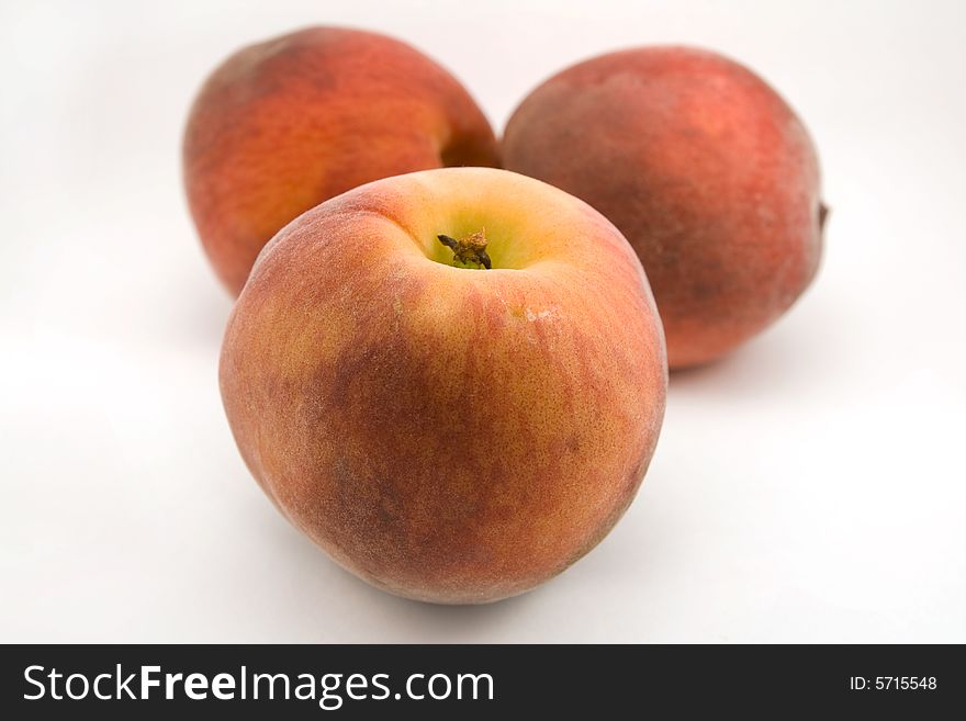 Three peaches isolated on white