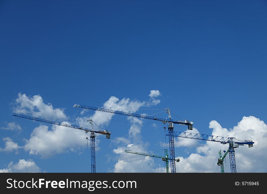 Construction cranes against nice clouds on a sky