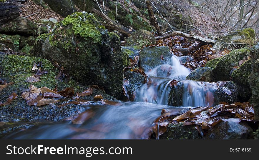 Beautiful waterfall between vegetation and stones