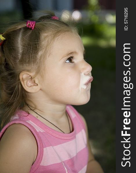 Little cute girl drinking yoghurt