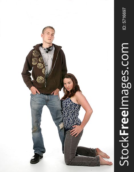 Grunge style man standing while girlfriend kneels next to him. Grunge style man standing while girlfriend kneels next to him