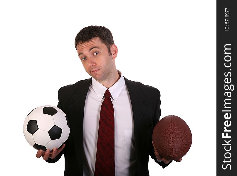 Young Businessman in a quandry over soccer vs football. Young Businessman in a quandry over soccer vs football