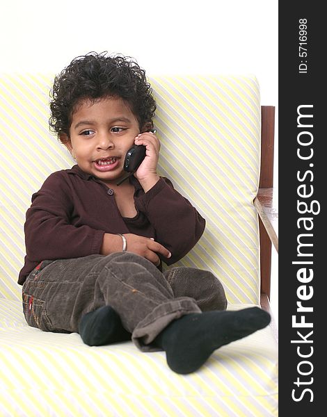 Young Asian Indian boy holding cell phone and smiling. Young Asian Indian boy holding cell phone and smiling