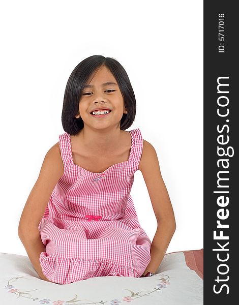 Young pretty Eurasian Chinese girl in pink dress seated on floor smiling. Young pretty Eurasian Chinese girl in pink dress seated on floor smiling