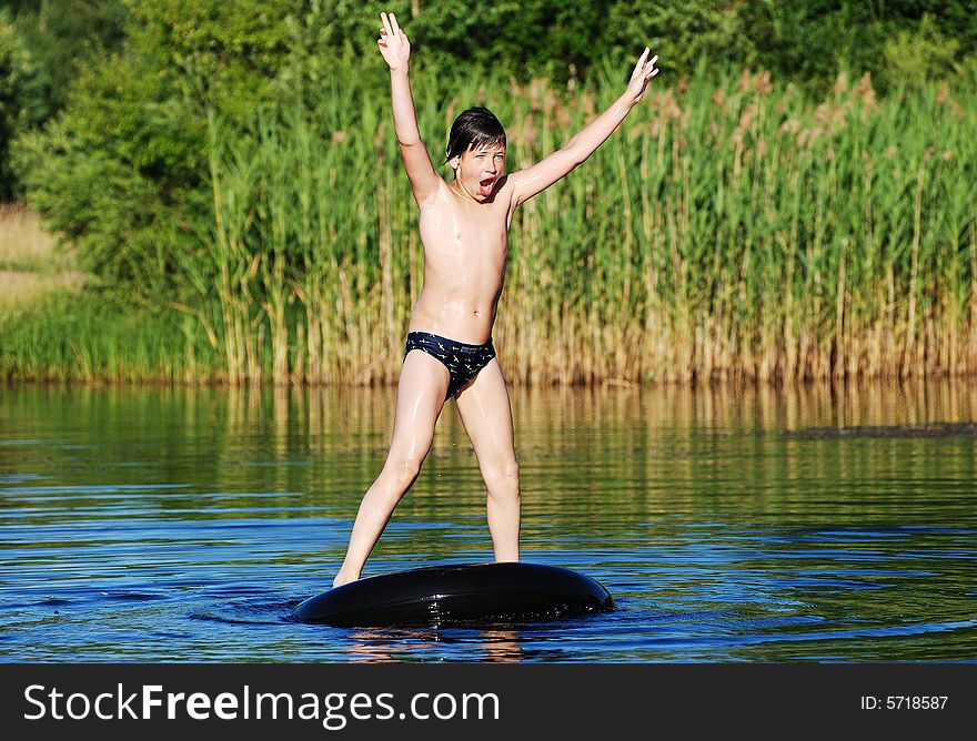 The boy finally stood up on a floating tube in a small lake. The boy finally stood up on a floating tube in a small lake.