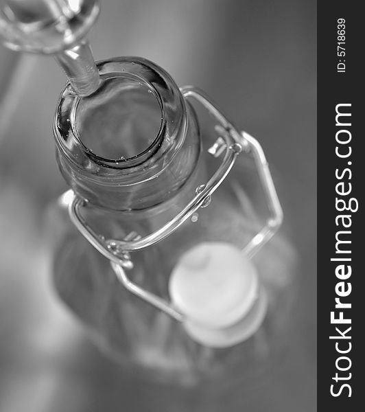 B & W (black and white) picture of water dripping into a bottle seen from above.