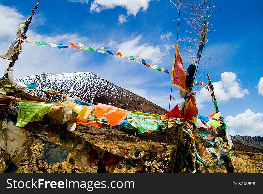 Prayer flag is waving with the blue sky and snow mountain background,the mountian is near Xizang(Tibet),china. Prayer flag is waving with the blue sky and snow mountain background,the mountian is near Xizang(Tibet),china