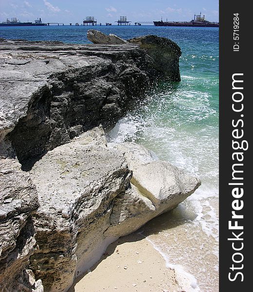 The wave splashes over eroded rocky coast in Freeport on Grand Bahama Island, The Bahamas.