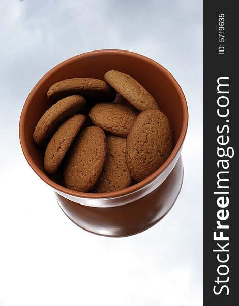 Oat cookies in a brown ceramic bowl on a mirror
