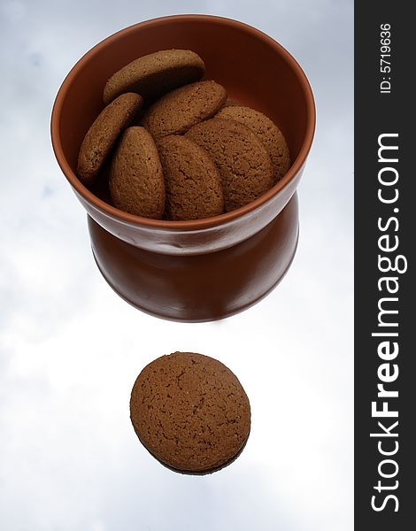 Oat cookies in a brown ceramic bowl on a mirror