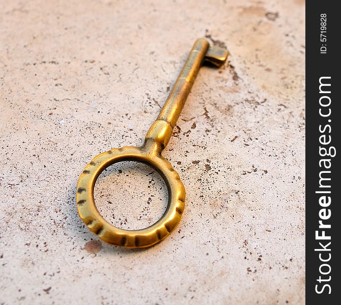 An old brass key on a marble board. An old brass key on a marble board.