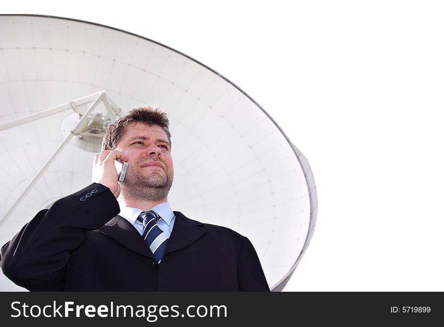 Businessman infront of big satellite dish isolated on white. Businessman infront of big satellite dish isolated on white