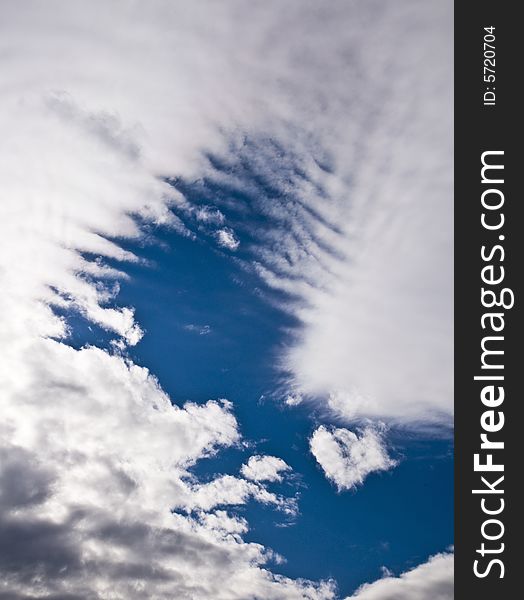 Deep blue sky clearing up between tearing apart white heavy clouds. Deep blue sky clearing up between tearing apart white heavy clouds.