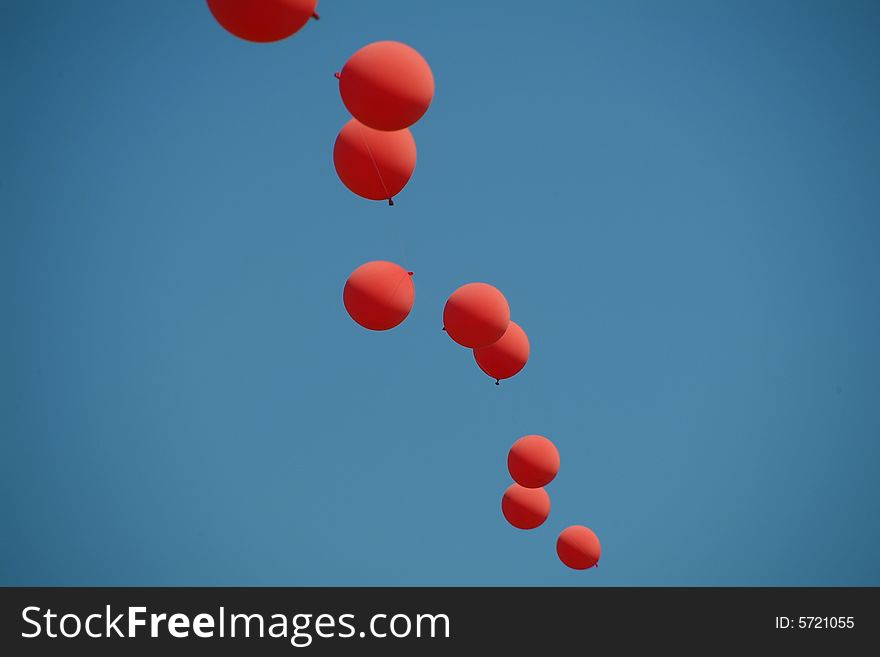 Red and blue balloons strung together against sky. Red and blue balloons strung together against sky