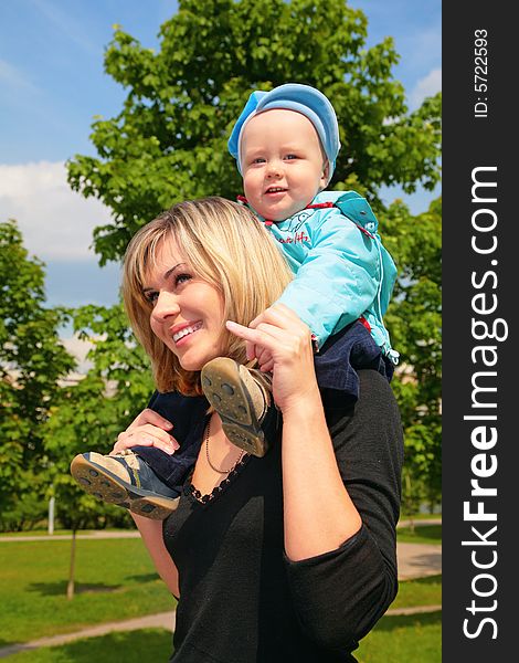 Mother with the child on shoulders outdoor