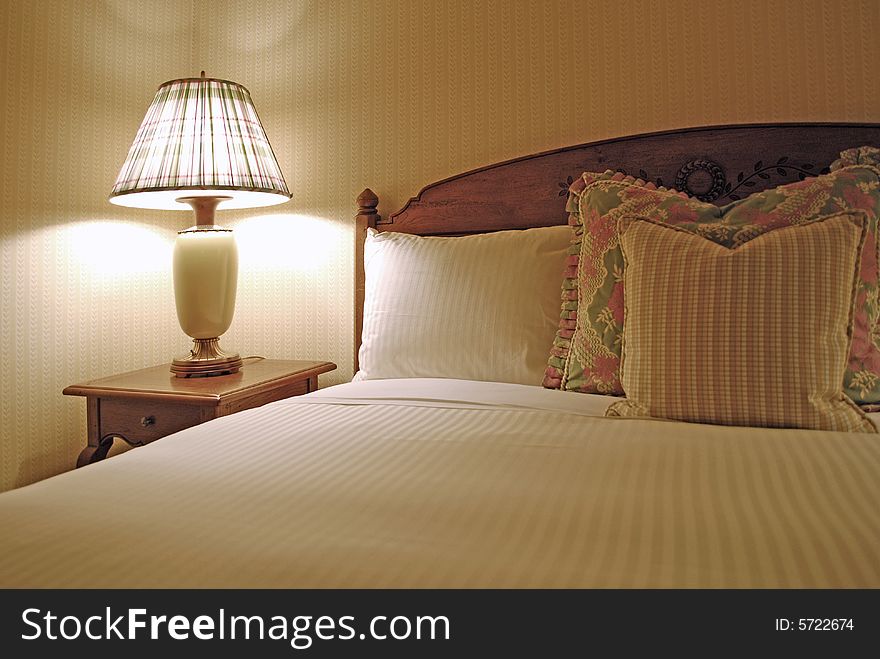 Group of several pillows on a bed with headboard. Group of several pillows on a bed with headboard