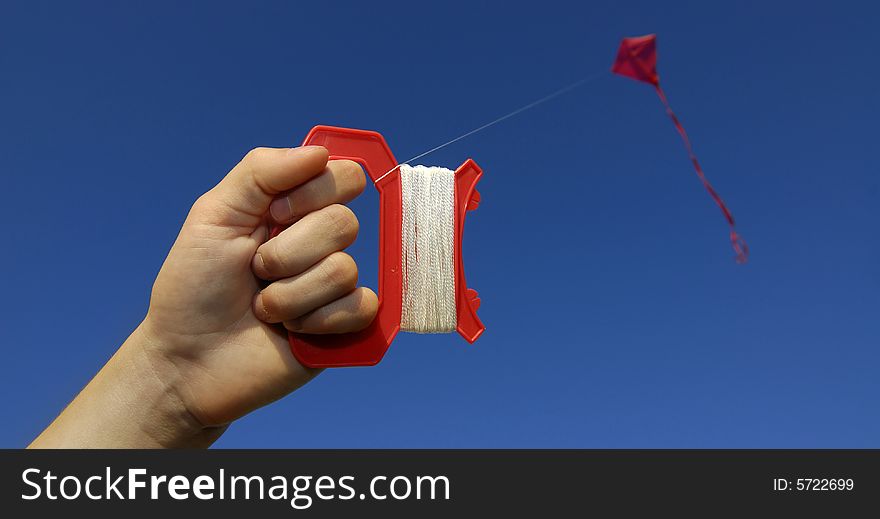 Girl flying a kite in a park with blue sky