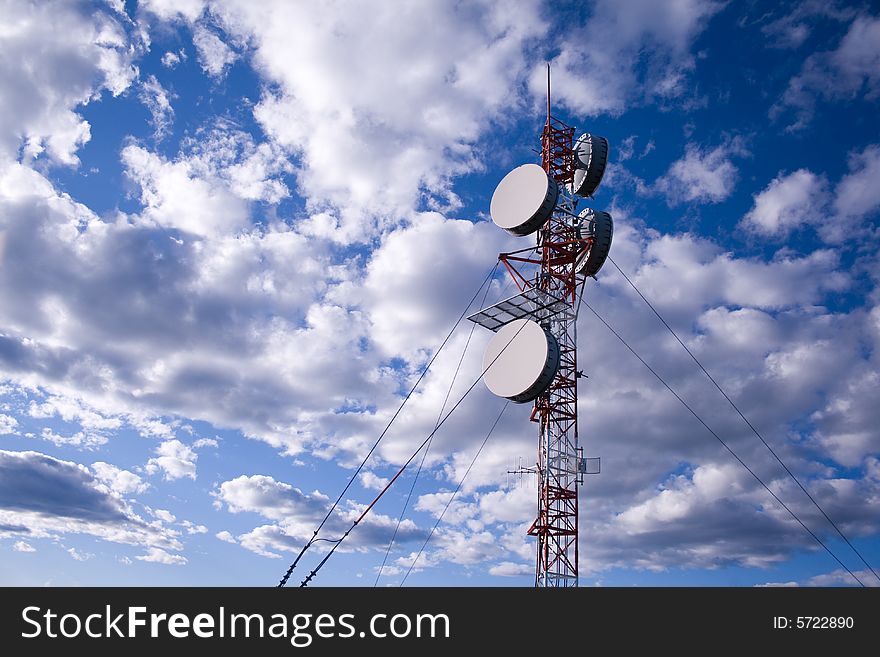 A lattice communication tower with clouds in behind. A lattice communication tower with clouds in behind