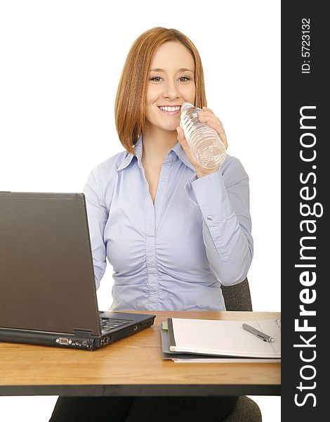 Young caucasian woman in casual dress working on her desk and drinking bottle water. Young caucasian woman in casual dress working on her desk and drinking bottle water