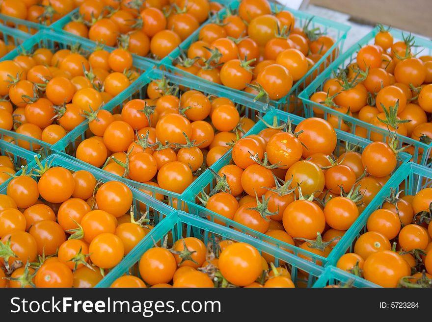 Baskets of orange tomatoes at a local farmers' market. Baskets of orange tomatoes at a local farmers' market