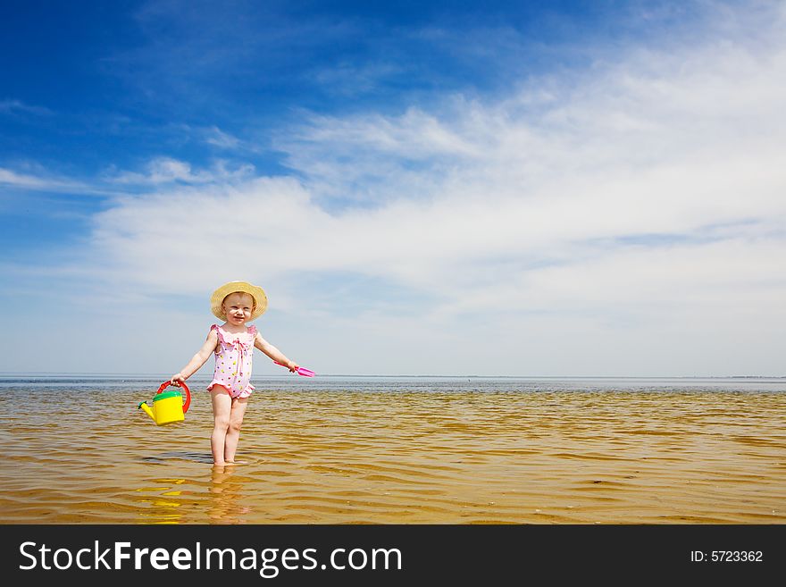 Small girl with watering-pot on the seashore. Small girl with watering-pot on the seashore