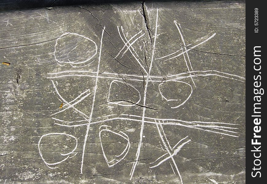 A game of Tic Tac Toe or Naughts and Crosses scratched in to a park bench. A game of Tic Tac Toe or Naughts and Crosses scratched in to a park bench.