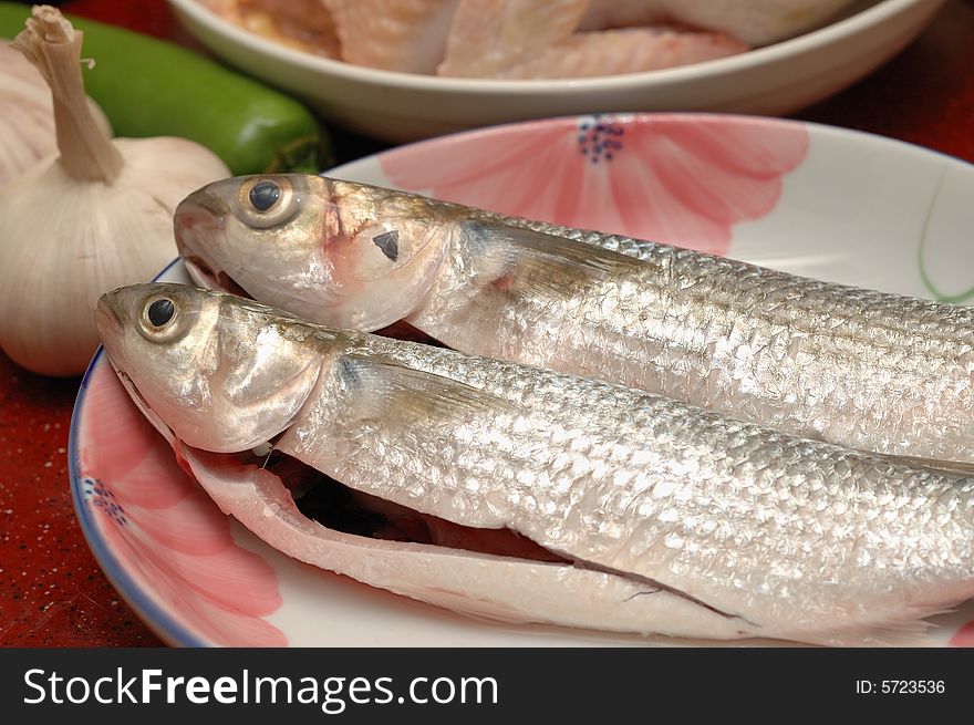 Two fishes in the dish, ready for cooking. Two fishes in the dish, ready for cooking.