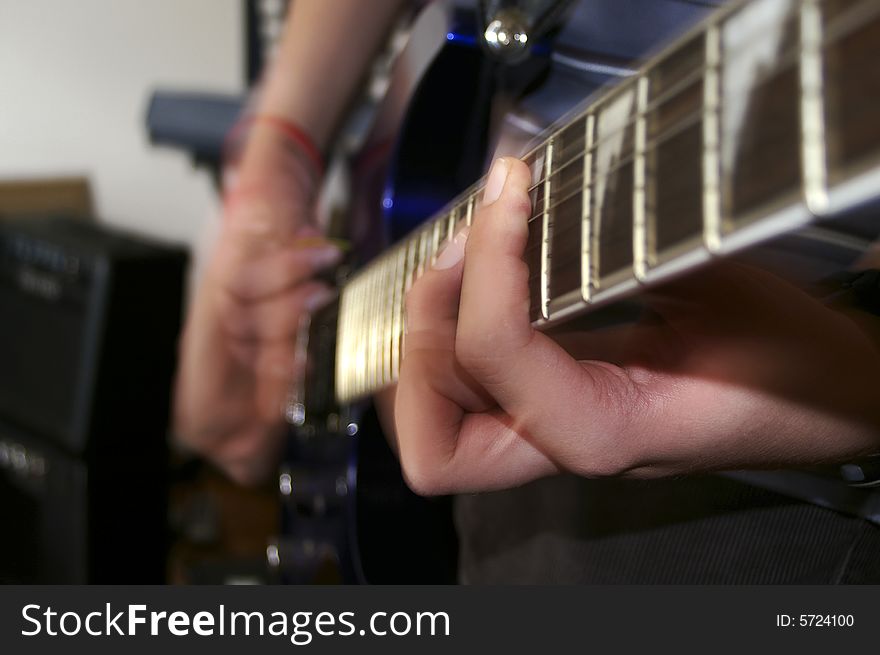 A guitarist playing guitar at band rehearsal. Selective focus down the frets. Photo by Daniel Gregoric. A guitarist playing guitar at band rehearsal. Selective focus down the frets. Photo by Daniel Gregoric