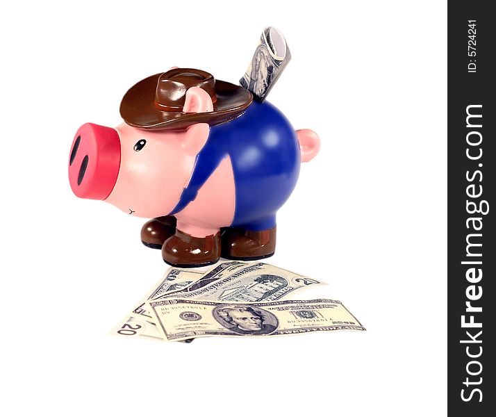 Coloured piggy bank sits on cash with cash in slot. Coloured piggy bank sits on cash with cash in slot