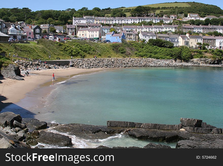 Small beach with man in distance looking out to sea. Small beach with man in distance looking out to sea