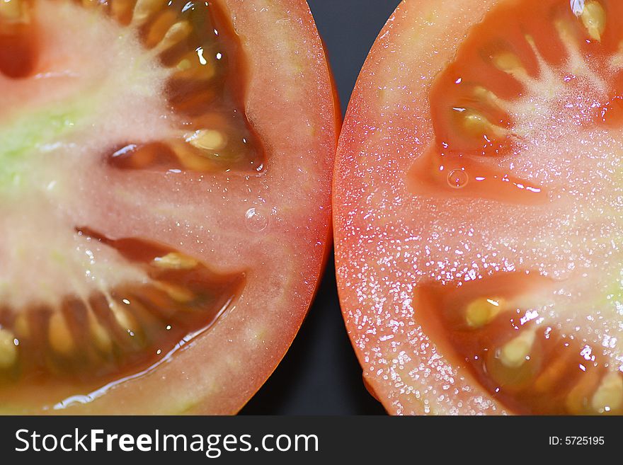 Close up view of a half sliced tomatoe, showing it's seeds. Close up view of a half sliced tomatoe, showing it's seeds.