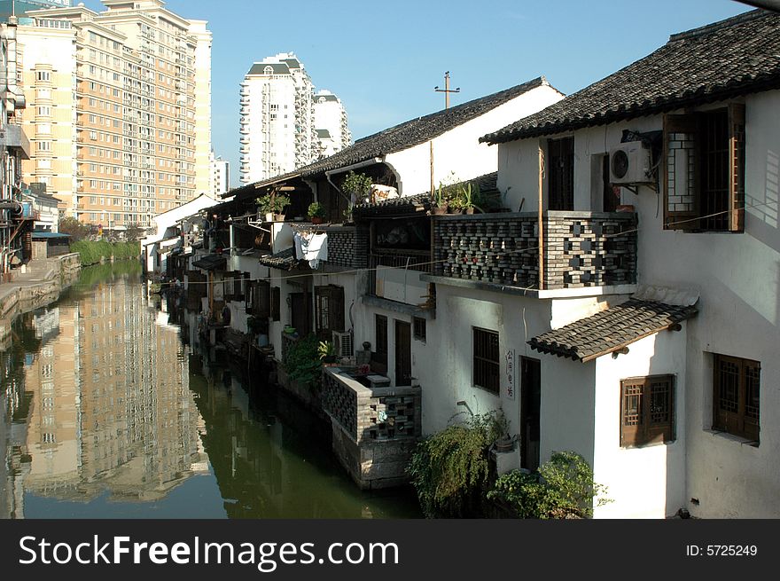 China, Zhejiang province, old town - Shaoxing with historical CanQiao street. Residential area is surrouded by water canals, which were water-roads for transportation in ancient times. Shaoxing is one of few watertowns in Zhejiang province. Ancient houses surrounded by modern residential area. China, Zhejiang province, old town - Shaoxing with historical CanQiao street. Residential area is surrouded by water canals, which were water-roads for transportation in ancient times. Shaoxing is one of few watertowns in Zhejiang province. Ancient houses surrounded by modern residential area.