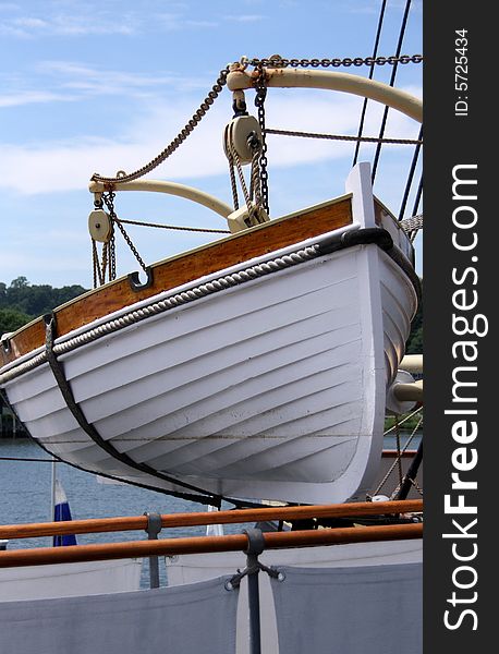 A white lifeboat hanging on a ship's side