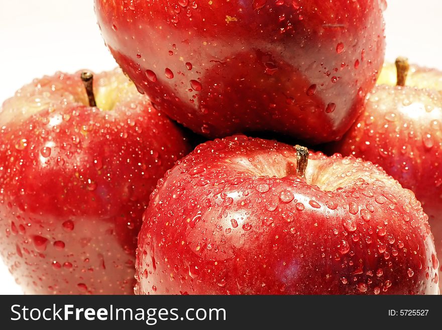 Bunch of red apples, on top of each other, isolated on a white background, with drops of water. Bunch of red apples, on top of each other, isolated on a white background, with drops of water.