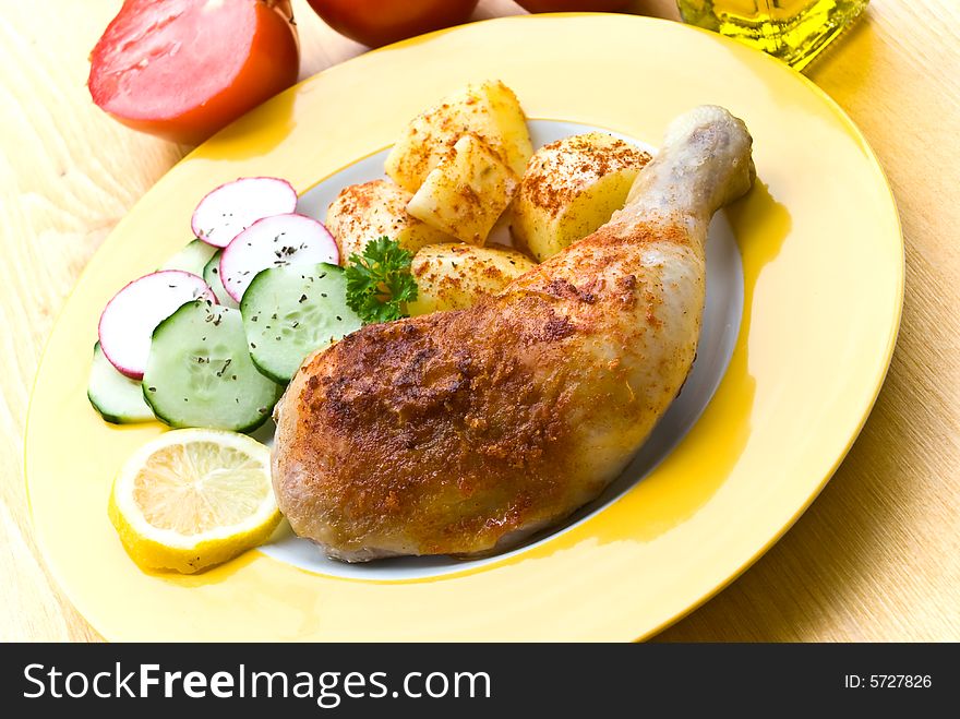 Fried chicken with fried potatoes, and cucumber,tomato,radish.