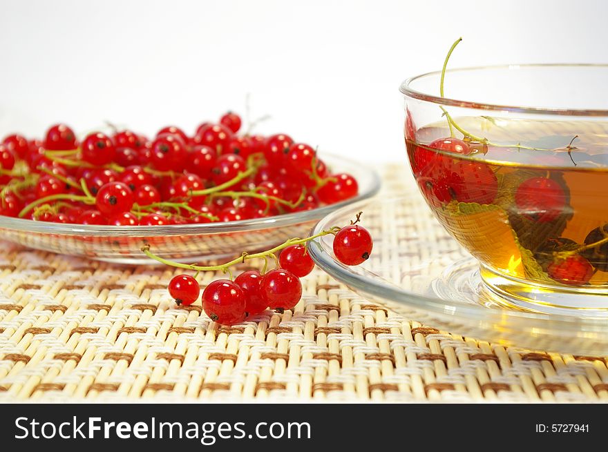 Red currant and herbal tea in a transparent cup. Red currant and herbal tea in a transparent cup