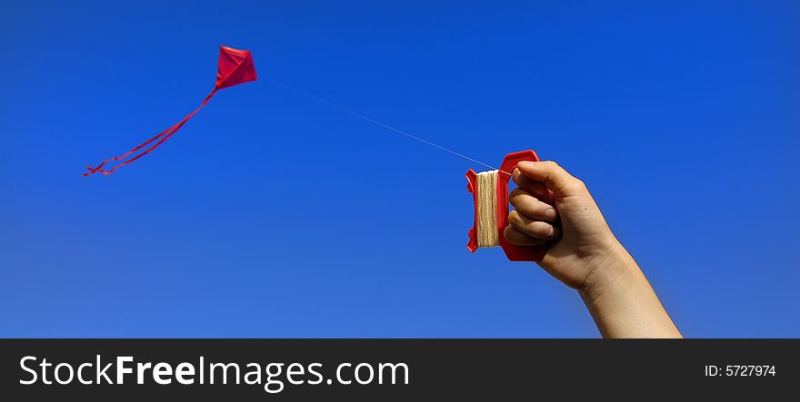 Girl flying a kite in a park with blue sky