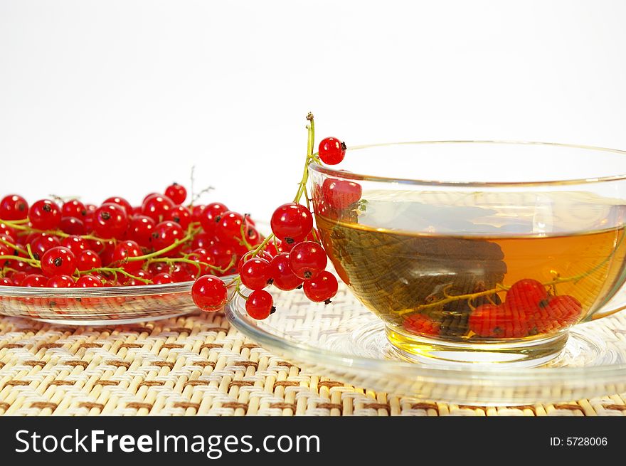 Red currant and tea in a transparent cup