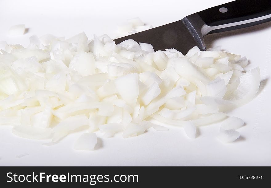 Chopping fresh white onion on a cutting board with knife. Chopping fresh white onion on a cutting board with knife