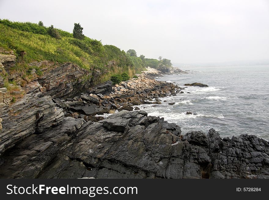 Mist and fog rolling in on a rocky shoreline