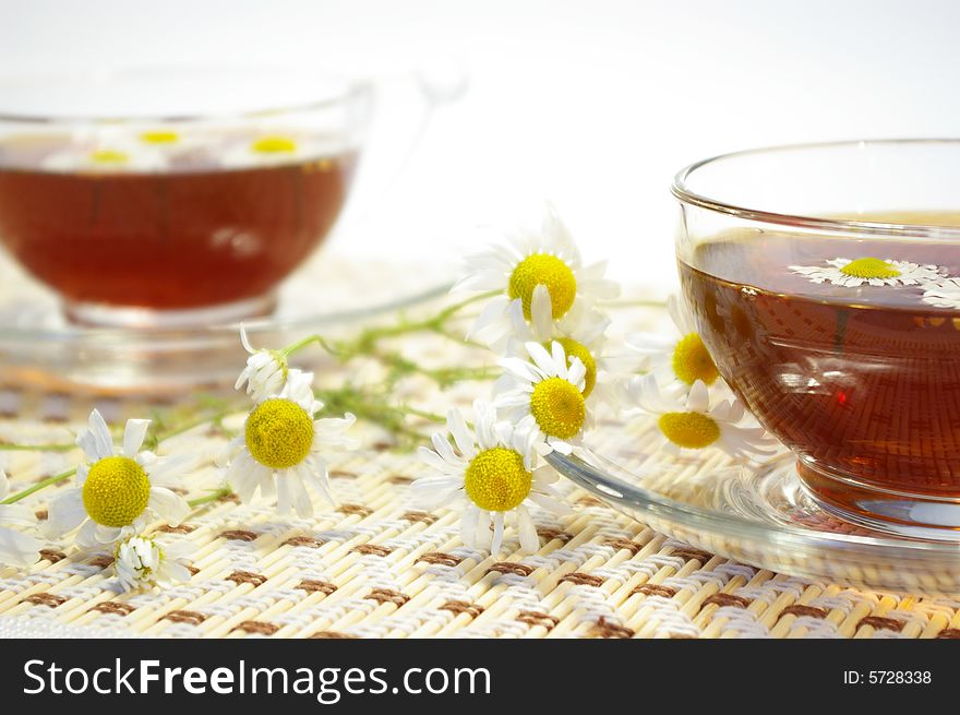 Cup of herbal tea and chamomile blossoms. Cup of herbal tea and chamomile blossoms