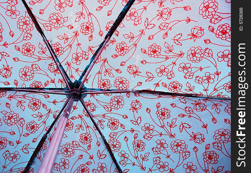 A photograph of the inside of an opened umbrella covered in raindrops. A photograph of the inside of an opened umbrella covered in raindrops