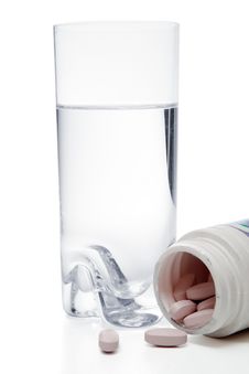 Glass With Water And Pills In Container, Isolated Royalty Free Stock Photography