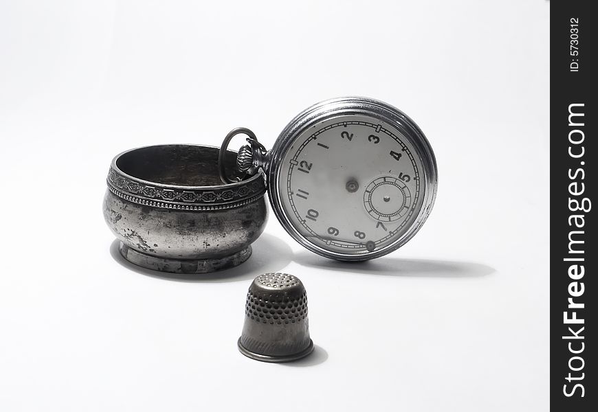Pocket watch; household goods; white background; salt-cellarsilver; thimble; clock. Pocket watch; household goods; white background; salt-cellarsilver; thimble; clock