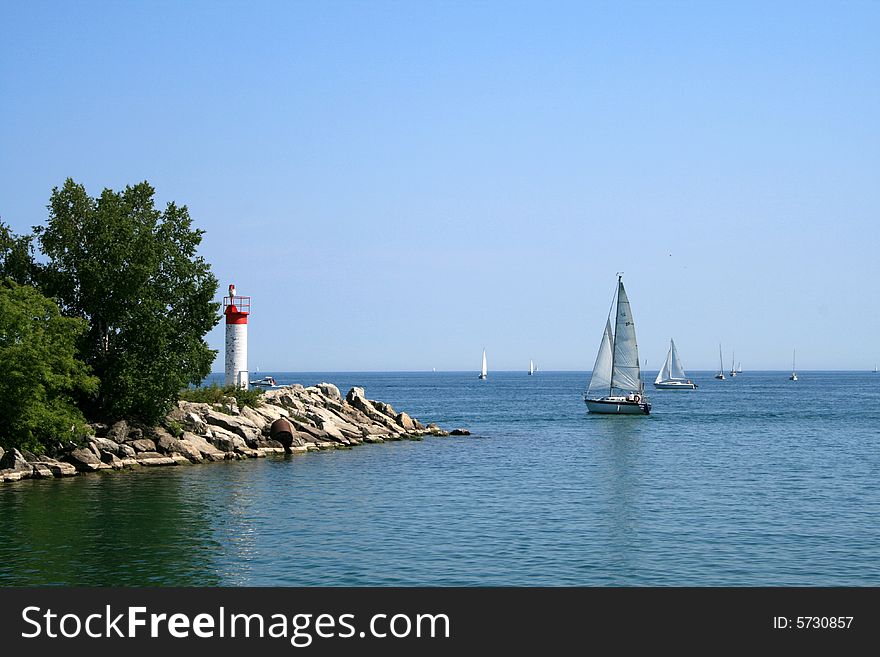 Sea landscape with the white lighthouse and yachts. Sea landscape with the white lighthouse and yachts